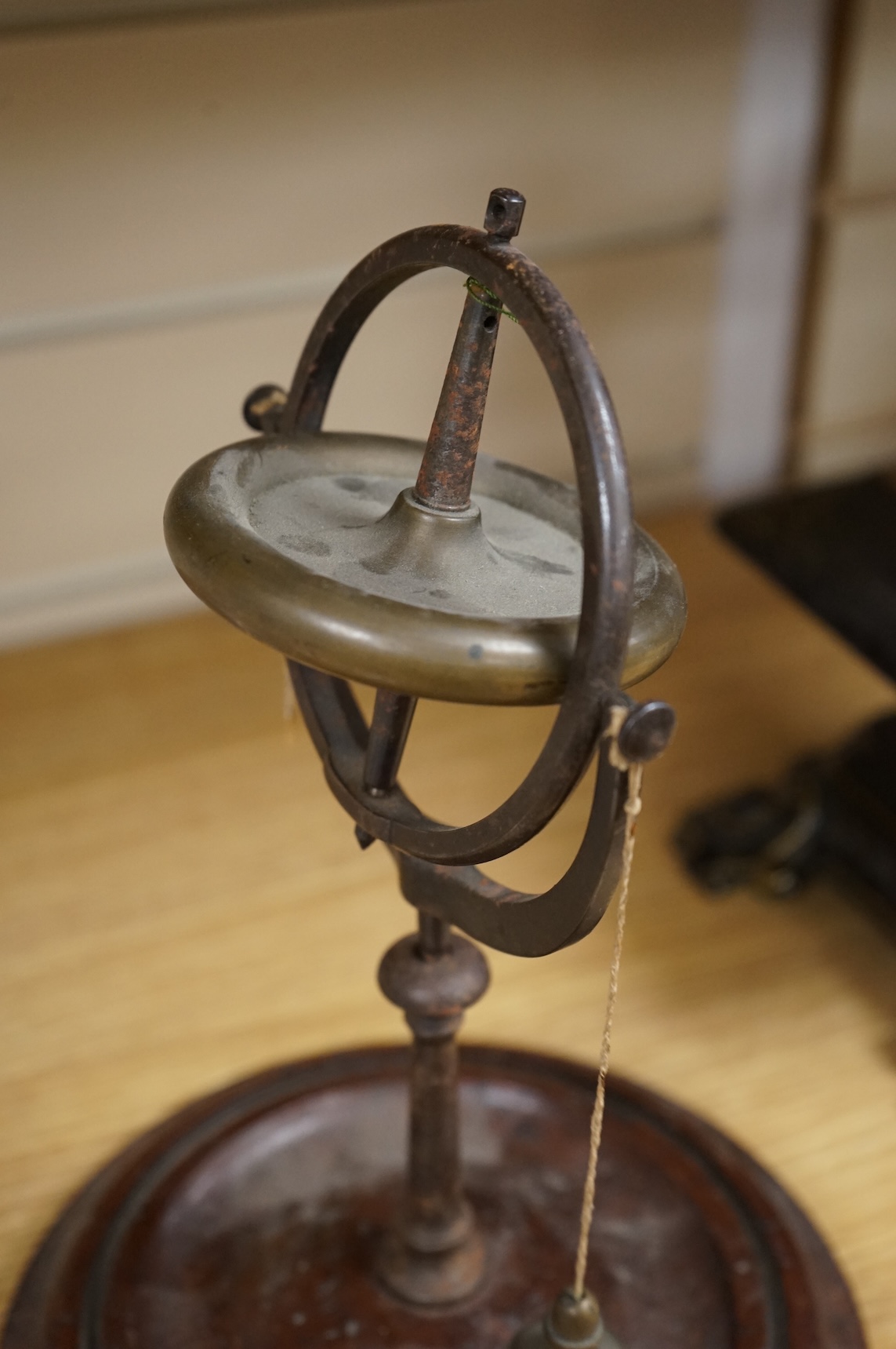 A 19th century brass gyroscope on a turned mahogany base, 26cm high.